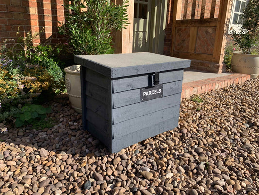 Dark Grey DelSafe wooden parcel delivery box with grey felt roof in a garden setting