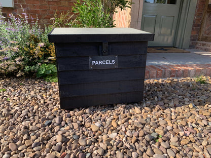 Black DelSafe wooden parcel delivery box in a garden setting